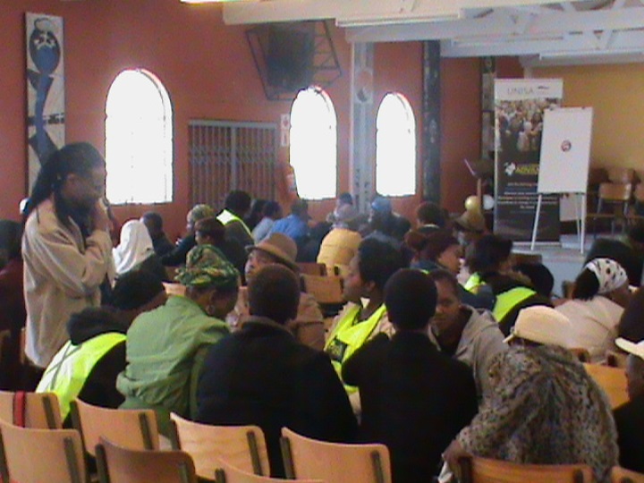 Facilitator Solomuzi Mabuza interacting with participants doing group work in the Faith Communities and Wellbeing workshop